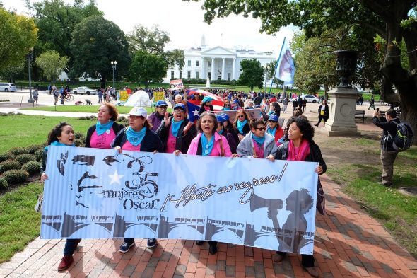 Women marching with a banner for the freedom of Oscar Lopez
