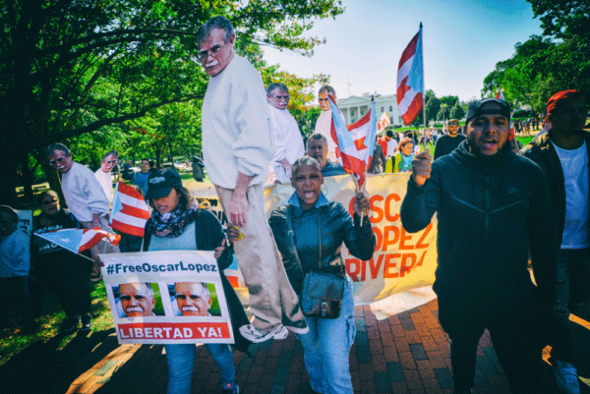 Supporters of Oscar's freedom proudly marching with placards and flags. 